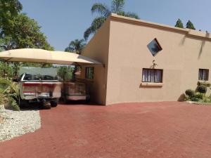 a car parked outside of a house with an umbrella at Zenith Guesthouse in Pretoria