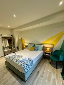 a bedroom with a large bed and a green chair at Apidalos Apartments in Corfu
