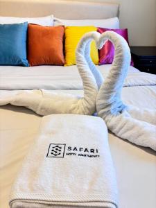 two swans towels sitting on a bed with a couch at Safari Hotel Apartments in Ajman 