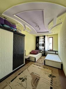 - un salon avec deux lits et un plafond dans l'établissement Апартаменты ЛЮКС в центре, à Samarcande
