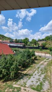 a building with a red roof and a dirt road at Casa Mario 2 in Oradea