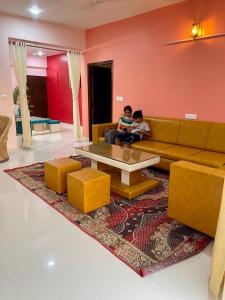 two people sitting on a couch in a living room at Royal Rajvilas Heights in Udaipur