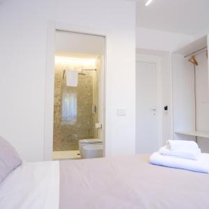 a white room with a bed and a bathroom at Pellarooms Quality Beb in Pellaro +122 photos