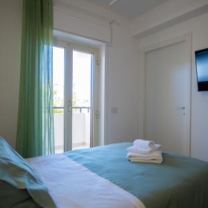 a bedroom with a bed with towels on it at Pellarooms Quality Beb in Pellaro