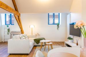 Loft Gent في خنت: غرفة معيشة مع أريكة بيضاء وطاولة