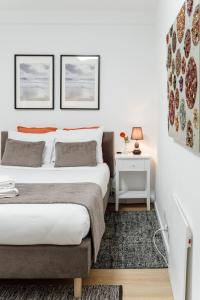 een slaapkamer met 2 bedden en een nachtkastje met een lamp bij Porto Ribeira RC Traseiras in Porto