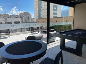 a room with a ping pong table on a balcony at Studio Aconchegante in Poços de Caldas