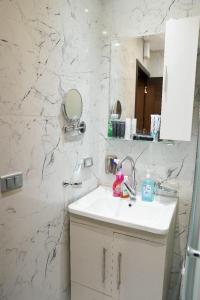 Baño blanco con lavabo y espejo en مدينه 15مايو en Ḩulwān