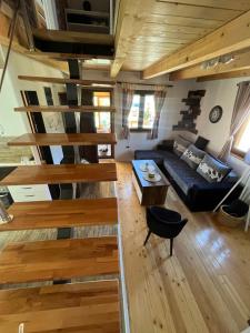 a living room with wooden stairs in a house at Vikendica Kraljica planina in Konjska Reka