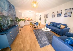ein Wohnzimmer mit einem blauen Sofa und einem TV in der Unterkunft River Lux Suite - 5 min to HBF in Wetzlar