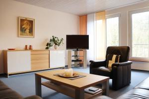 a living room with a couch and a tv and a table at Haus St. Josef in Vallendar