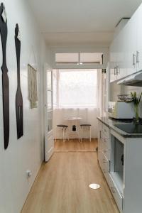 een keuken met witte muren en een houten vloer bij Porto Ribeira RC Traseiras in Porto