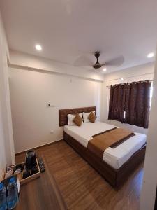 um quarto com uma cama grande num quarto em Meadows Inn em Mysore