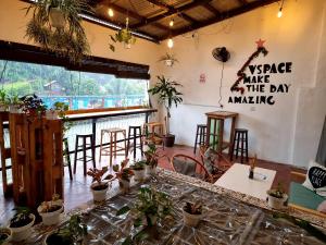 een kamer met een tafel met planten aan de muur bij V Space CAPSULE CAFE MELAKA in Melaka