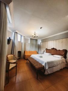 a bedroom with a large bed and a chair at Seringal Hotel in Manaus