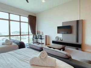 a hotel room with two beds and a flat screen tv at 2-4 Pax Spacious Living @ Mount Austin, JB #02 in Johor Bahru