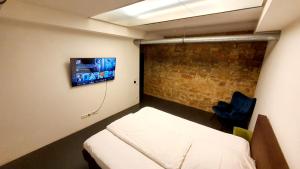 um quarto com uma cama e uma televisão na parede em Loft im Szeneviertel Mannheims em Mannheim