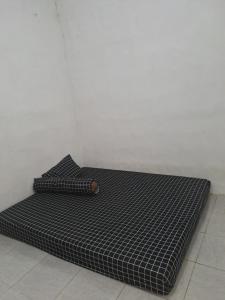 a black mattress on the floor in a room at Teras Abah homestay in Babagan