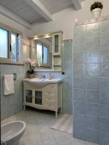 a bathroom with a sink and a toilet and a mirror at Villa Primofiore di Vendicari in La Banca +38 photos