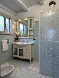 a bathroom with a sink and a toilet and a mirror at Villa Primofiore di Vendicari in La Banca