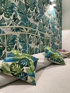 a bed with two pillows and a blue and green wall at Villa Primofiore di Vendicari in La Banca