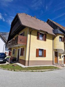 ein Haus mit braunen Fensterläden auf einer Straße in der Unterkunft Kometer soba in Bovec