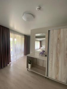 ein Schlafzimmer mit einem großen Spiegel und einem Bett in der Unterkunft Chorna Skelya Resort & Wellness in Wynohradiw