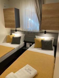 una camera d'albergo con due letti e una finestra di mobile home MIRNA a Biograd na Moru