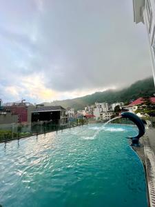 a pool with a water slide in a city at Tam Đảo Gold Hotel in Tam Ðảo