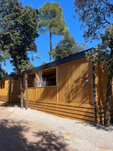 a wooden house with a black roof at mobile home MIRNA in Biograd na Moru