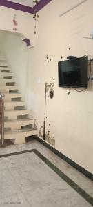 een kamer met een trap en een tv aan de muur bij 1 BHK VILLA. PRIVATE VILLA. NEAR ROCK BEACH. in Pondicherry