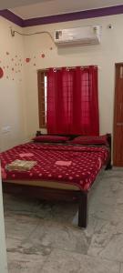 een bed met een rood dekbed in een kamer bij 1 BHK VILLA. PRIVATE VILLA. NEAR ROCK BEACH. in Pondicherry