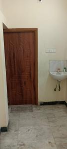 een badkamer met een houten deur en een wastafel bij 1 BHK VILLA. PRIVATE VILLA. NEAR ROCK BEACH. in Pondicherry