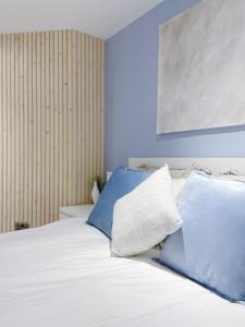 a bed with two blue and white pillows on it at Garden Apartment - Close to Town Centre - sleeps 6 in Buxton +17 photos