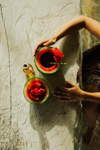 a person holding two slices of fruit on a table at Amaranthus Hotel in Doradal