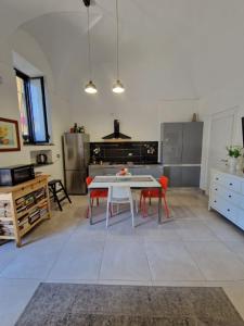 a kitchen with a white table and red chairs at Elvira Home in Catania