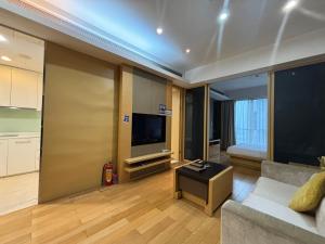 sala de estar con sofá y TV de pantalla plana en Guangzhou City Inn Hotel Apartment Pazhou en Guangzhou