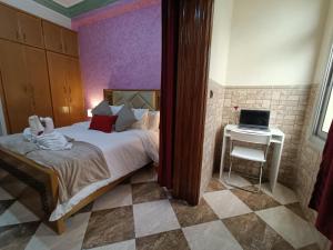- une chambre avec un lit et un bureau avec un ordinateur portable dans l'établissement Aljazeera apartment, à Tanger