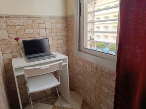 - un ordinateur portable sur un bureau dans une salle de bains avec fenêtre dans l'établissement Aljazeera apartment, à Tanger