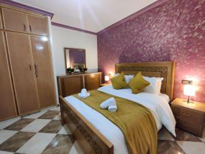 - une chambre avec un grand lit et un mur pourpre dans l'établissement Aljazeera apartment, à Tanger