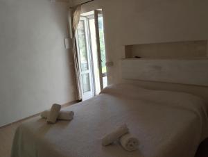 a white bedroom with a bed with two objects on it at La dimora di nonna Giuliana in Ostuni