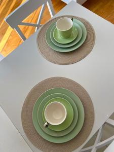 a table with two green plates and a cup on it at Mostar in Mostar