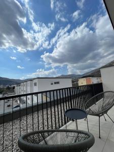 a balcony with two chairs and a table and a sky at Mostar in Mostar