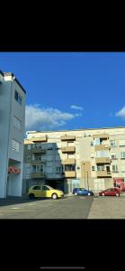 a yellow car parked in a parking lot next to a building at Mostar in Mostar +3 photos