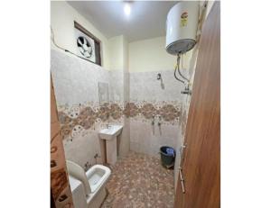 a bathroom with a toilet and a sink at Hotel Shree Galaxy, Kanpur in Kānpur