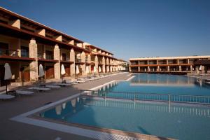 a hotel with two swimming pools and tables and chairs at Island Blue Hotel in Pefki Rhodes