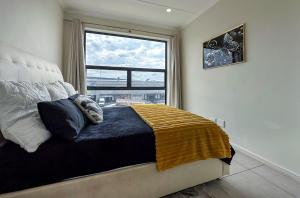 a bedroom with a bed with a large window at StayEasy Lux Apartment in Edenvale
