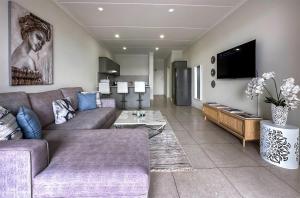 a living room with a couch and a tv at StayEasy Lux Apartment in Edenvale