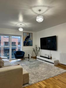 a living room with a couch and a flat screen tv at Luxury Lakeview Apartment in Dartford