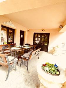 een patio met een tafel en stoelen en een bloempot bij Leaganul Bucovinei Guest House in Suceava